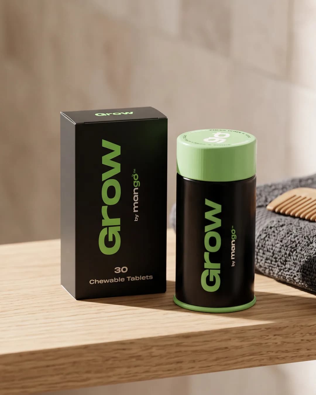 A black Grow tin with a green cap beside its box on a bathroom shelf